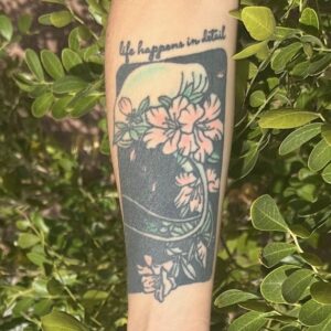 photo of forearm with "life happens in detail" written above a jellyfish and flowers